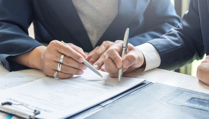 A group of business people sign a joint investment contract