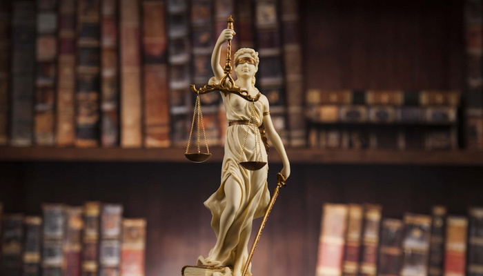 Antique statue of justice law books background