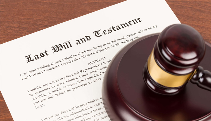 Last will and testament on yellowish paper with wooden judge gavel document is mock up