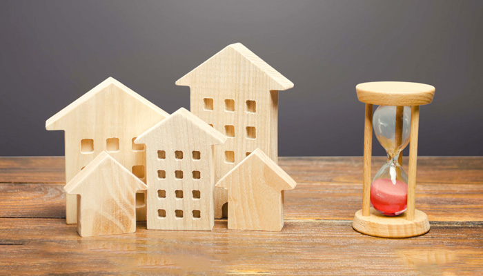 Wooden figures of houses and sand hourglass