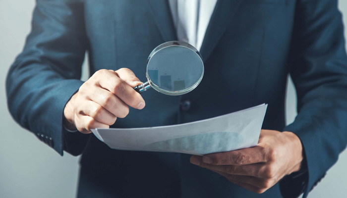 man hand magnifier and document