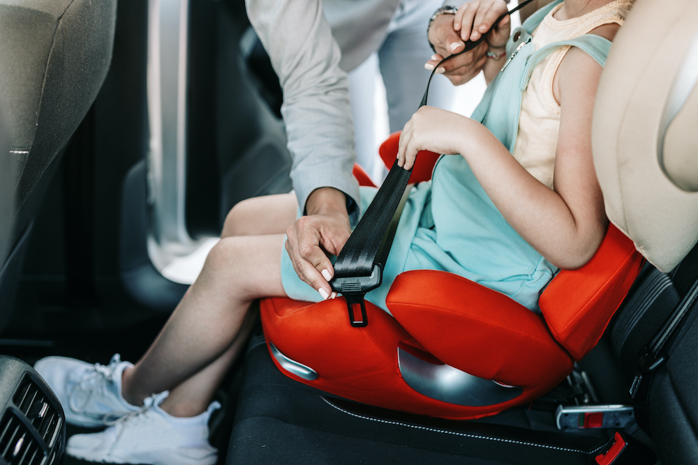 parent buckling child car seat