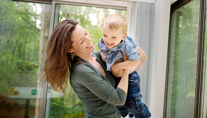 woman picking up her son smiling son